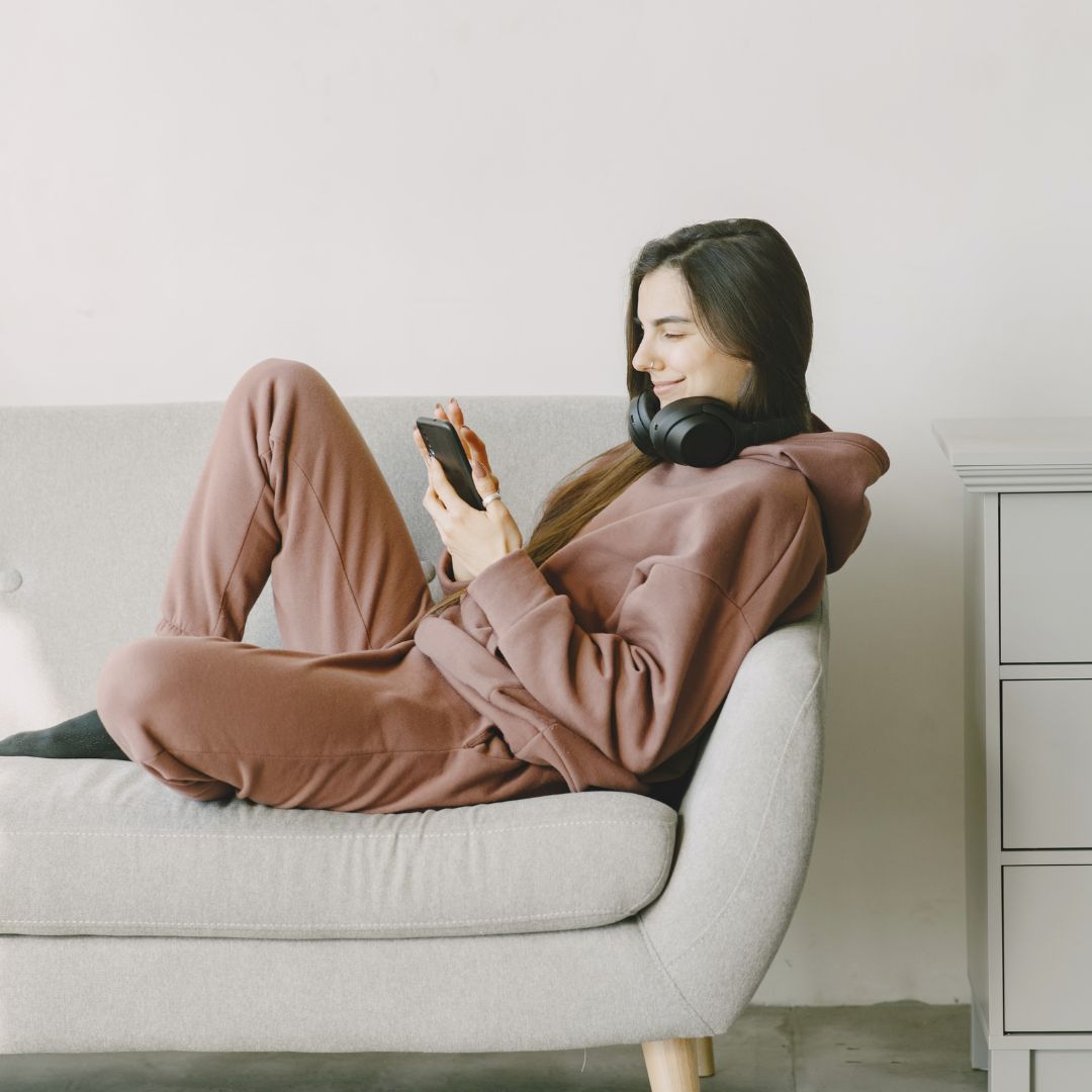 woman sitting on couch on phone